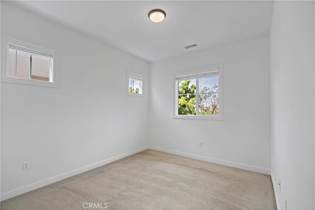 empty room featuring baseboards, visible vents, and carpet floors
