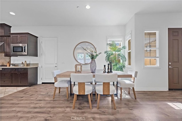 dining area featuring baseboards, light wood-style flooring, and recessed lighting