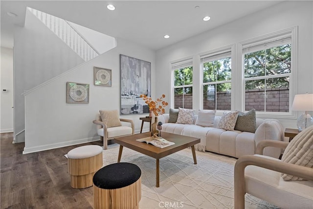 living area with baseboards, wood finished floors, and recessed lighting
