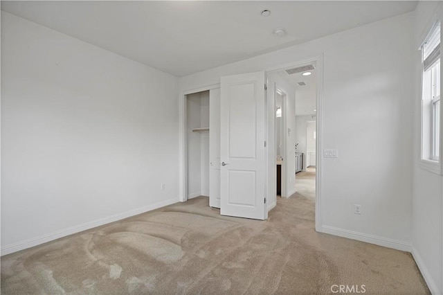 unfurnished bedroom featuring baseboards, carpet flooring, visible vents, and multiple windows