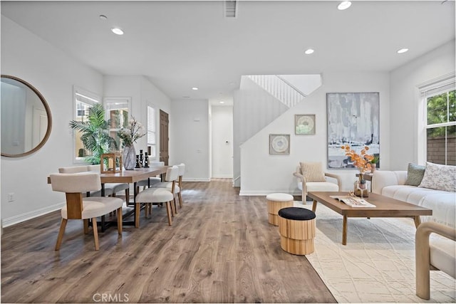 living area featuring baseboards, visible vents, wood finished floors, and recessed lighting