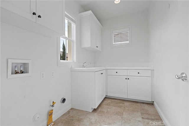 clothes washing area featuring hookup for a gas dryer, washer hookup, baseboards, a sink, and cabinet space