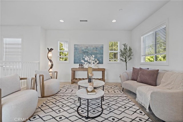 living area featuring baseboards, visible vents, and recessed lighting