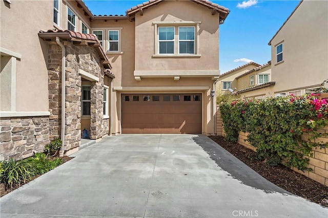 mediterranean / spanish-style home with driveway, stucco siding, an attached garage, and a tiled roof
