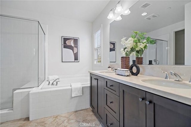 bathroom with a shower stall, double vanity, a sink, and a garden tub