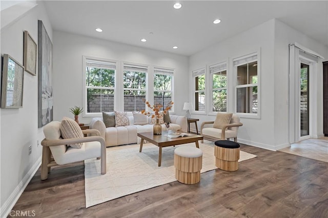 living area with baseboards, wood finished floors, and recessed lighting