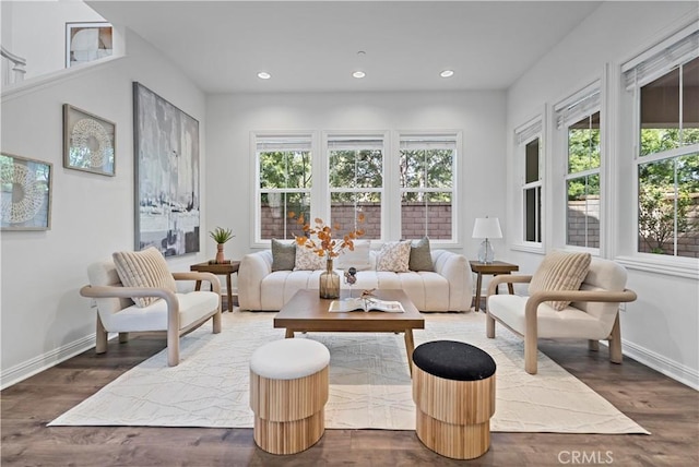 living area with baseboards, wood finished floors, and recessed lighting