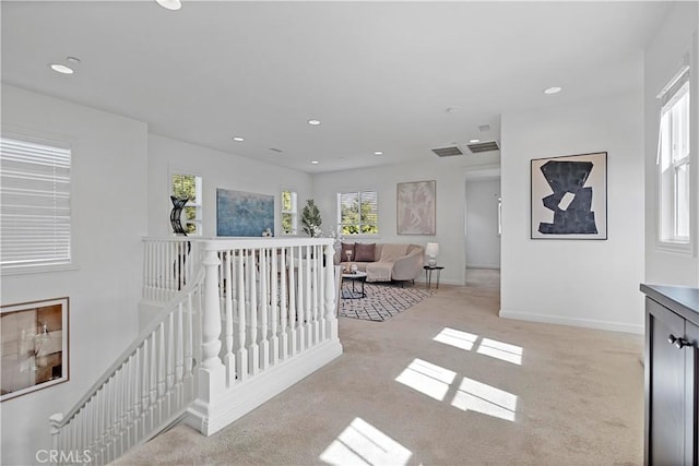 corridor featuring light carpet, baseboards, an upstairs landing, and recessed lighting