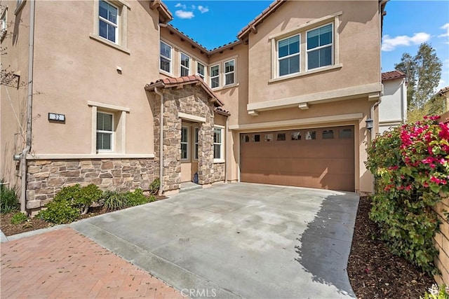 view of front of home featuring driveway, stucco siding, a garage, and a tiled roof
