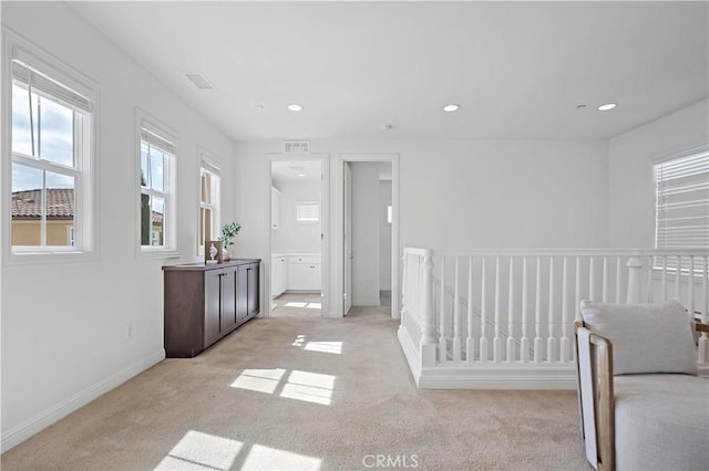 interior space with baseboards, visible vents, recessed lighting, and light carpet