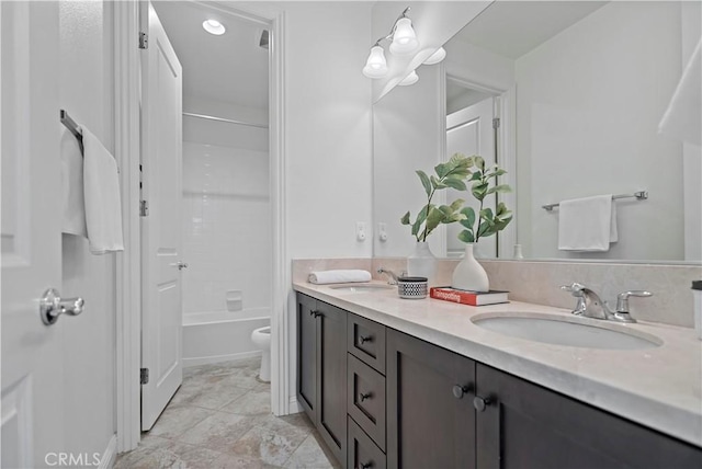 full bathroom with double vanity, toilet, shower / washtub combination, and a sink