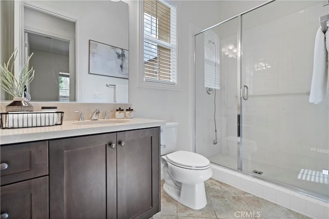 bathroom with a stall shower, toilet, and vanity