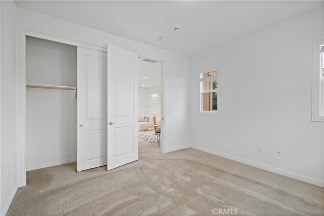 unfurnished bedroom featuring baseboards, visible vents, a closet, and carpet floors