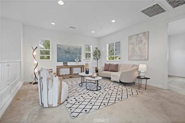 carpeted living room featuring a wealth of natural light, baseboards, recessed lighting, and visible vents