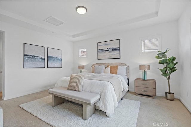 bedroom featuring a tray ceiling, baseboards, visible vents, and light colored carpet