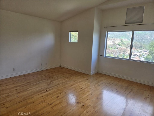 19392 Highridge Way, Trabuco Canyon, CA 92679 - spare room featuring lofted ceiling, baseboards, and light wood-type flooring