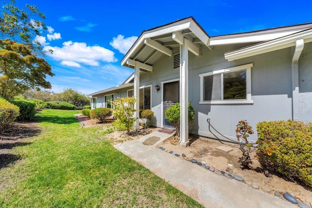 property entrance with a lawn and stucco siding