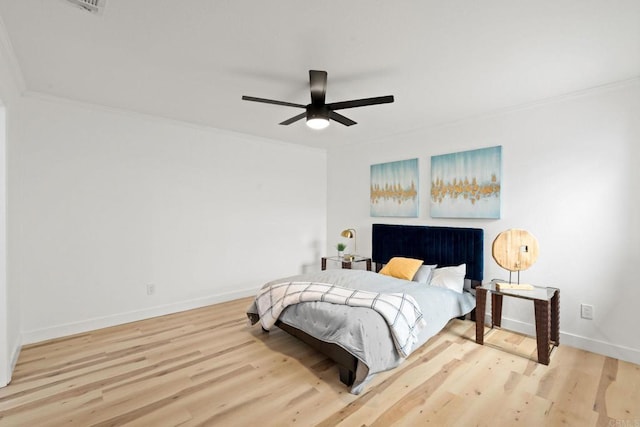 bedroom with ornamental molding, a ceiling fan, baseboards, and wood finished floors