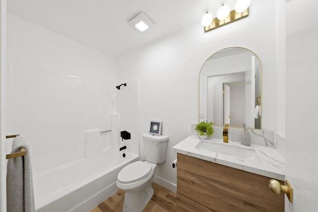 full bathroom featuring toilet, shower / tub combination, wood finished floors, baseboards, and vanity