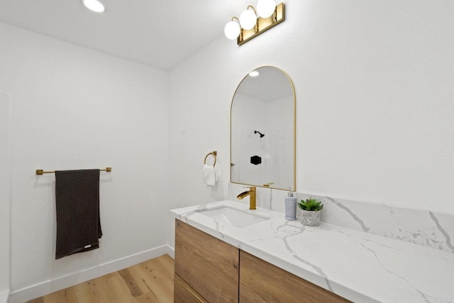 bathroom featuring baseboards, wood finished floors, and vanity