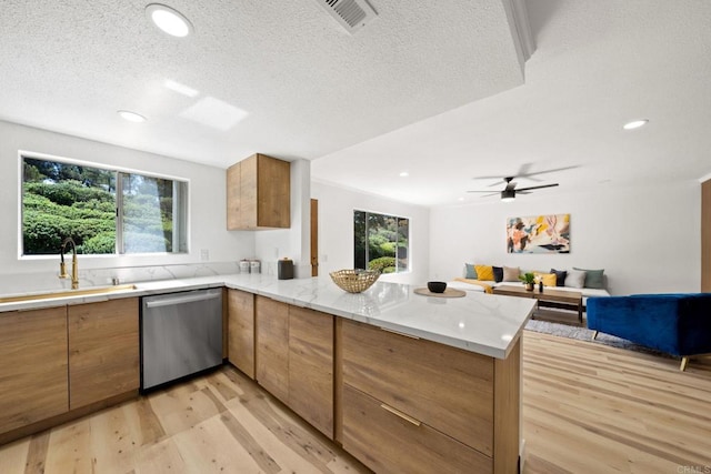 kitchen with visible vents, light wood-style flooring, a peninsula, brown cabinetry, and dishwasher