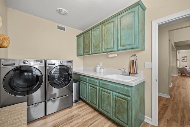 2185 Twain Ave, Carlsbad, CA 92008 - laundry area with washing machine and clothes dryer, cabinet space, light wood-style flooring, and baseboards