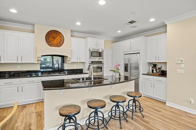 2185 Twain Ave, Carlsbad, CA 92008 - kitchen with a sink, appliances with stainless steel finishes, crown molding, a kitchen bar, and white cabinetry