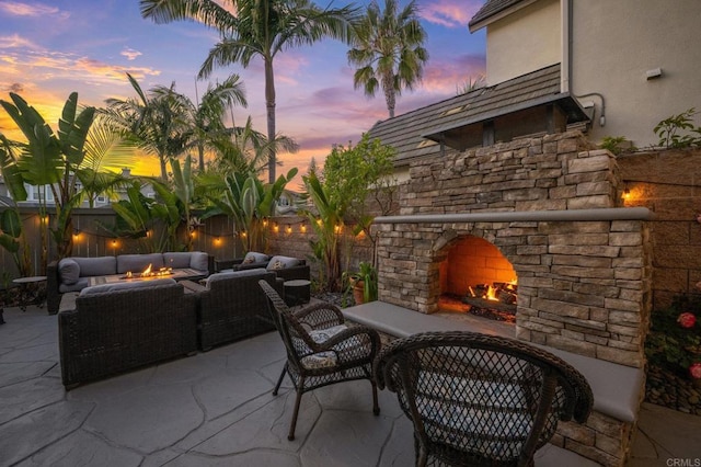 2185 Twain Ave, Carlsbad, CA 92008 - patio terrace at dusk featuring a patio area, an outdoor living space with a fireplace, and a fenced backyard