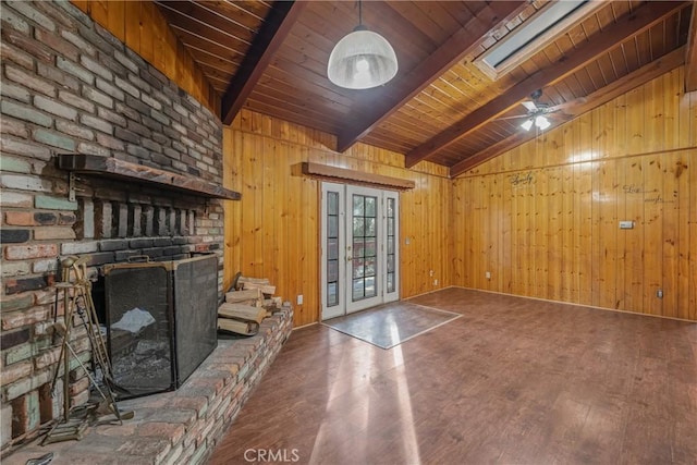 unfurnished living room with vaulted ceiling with beams, ceiling fan, wood walls, wood ceiling, and wood finished floors