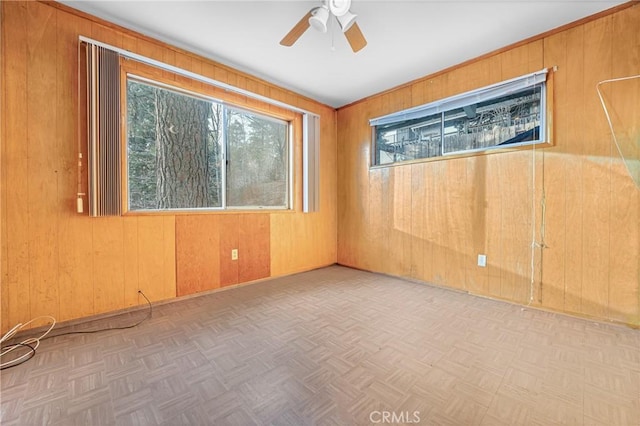 empty room with wooden walls and a ceiling fan