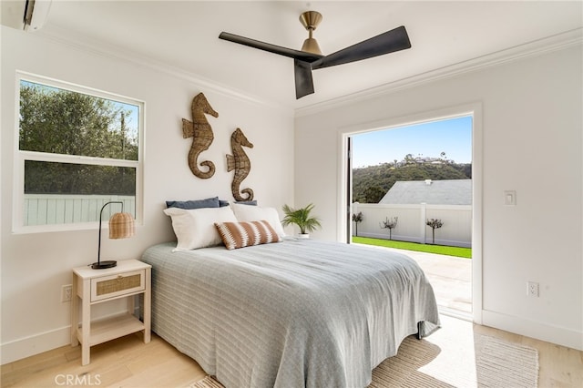 bedroom with access to exterior, light wood-style flooring, and multiple windows