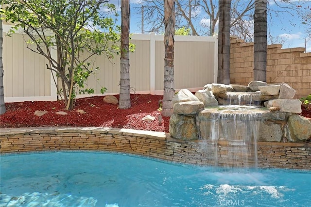 exterior space featuring a swimming pool and a fenced backyard