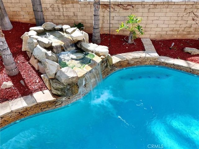 outdoor pool featuring fence