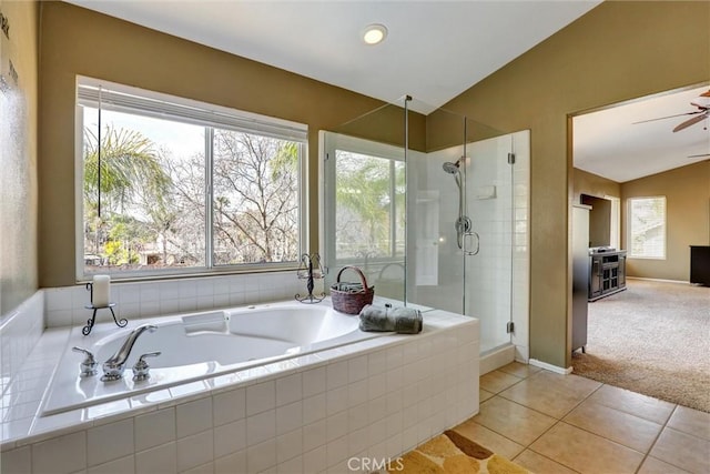 bathroom featuring vaulted ceiling, a wealth of natural light, a bath, and a stall shower