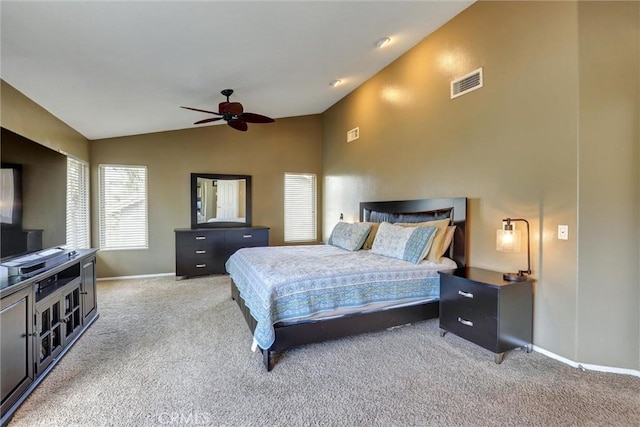 carpeted bedroom with visible vents, a ceiling fan, baseboards, and lofted ceiling