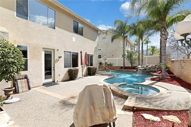 view of pool with a fenced backyard, a pool with connected hot tub, and a patio area