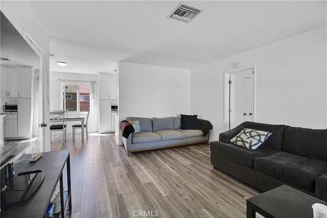 living area with light wood finished floors and visible vents