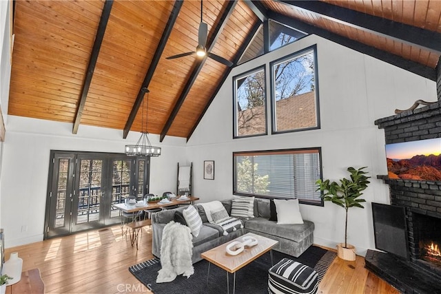 28886 Cedar Dr, Lake Arrowhead, CA 92352 - living room with a lit fireplace, wooden ceiling with exposed beams, hardwood / wood-style flooring, high vaulted ceiling, and plenty of natural light