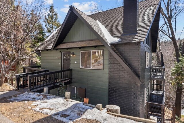 28886 Cedar Dr, Lake Arrowhead, CA 92352 - view of front of house featuring a chimney, stairway, a wooden deck, and brick siding