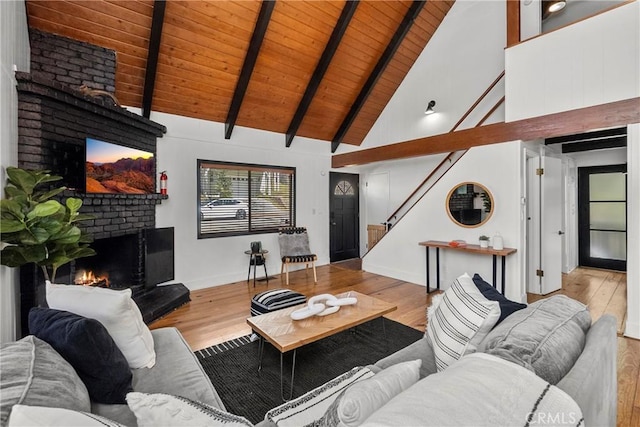 28886 Cedar Dr, Lake Arrowhead, CA 92352 - living room with a fireplace, wood ceiling with exposed beams, high vaulted ceiling, stairway, and wood finished floors