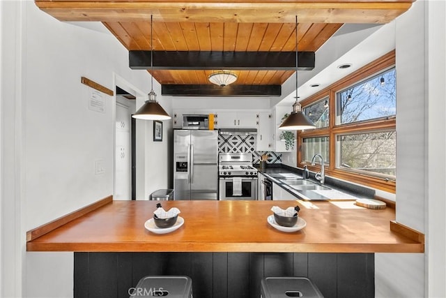 28886 Cedar Dr, Lake Arrowhead, CA 92352 - kitchen featuring stainless steel appliances, a sink, decorative backsplash, wood ceiling with exposed beams, and a peninsula