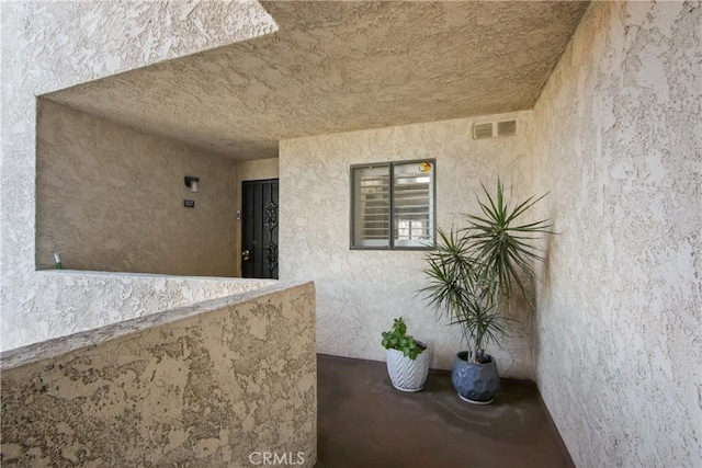 property entrance with visible vents and stucco siding