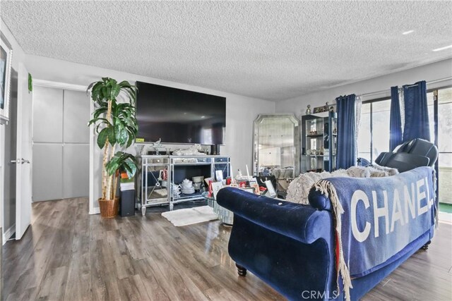 living room with a textured ceiling and wood finished floors