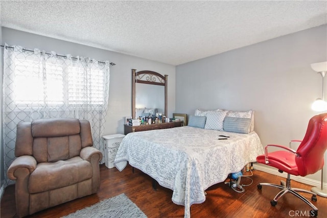 bedroom with a textured ceiling and wood finished floors