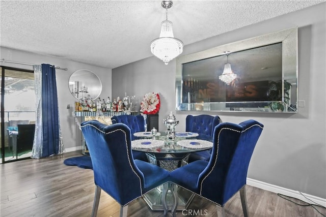 dining space with baseboards, an inviting chandelier, and a textured ceiling