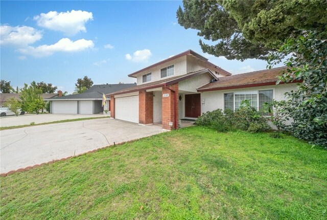 traditional-style house with a front lawn, concrete driveway, a garage, and stucco siding