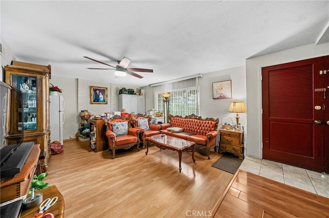 living room with light wood-style floors and a ceiling fan