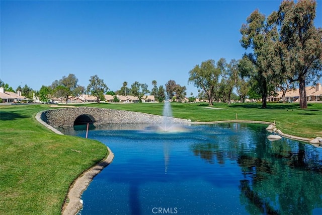 view of community featuring a water view, a residential view, and a lawn