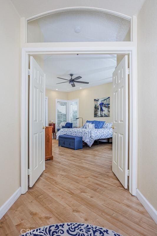 bedroom with baseboards, light wood finished floors, and ceiling fan
