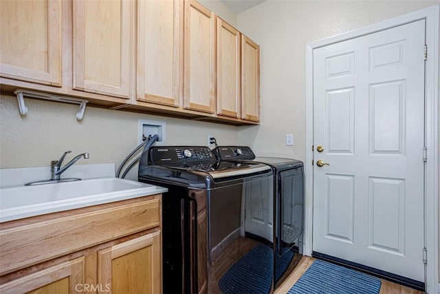 washroom with a sink, washing machine and clothes dryer, and cabinet space